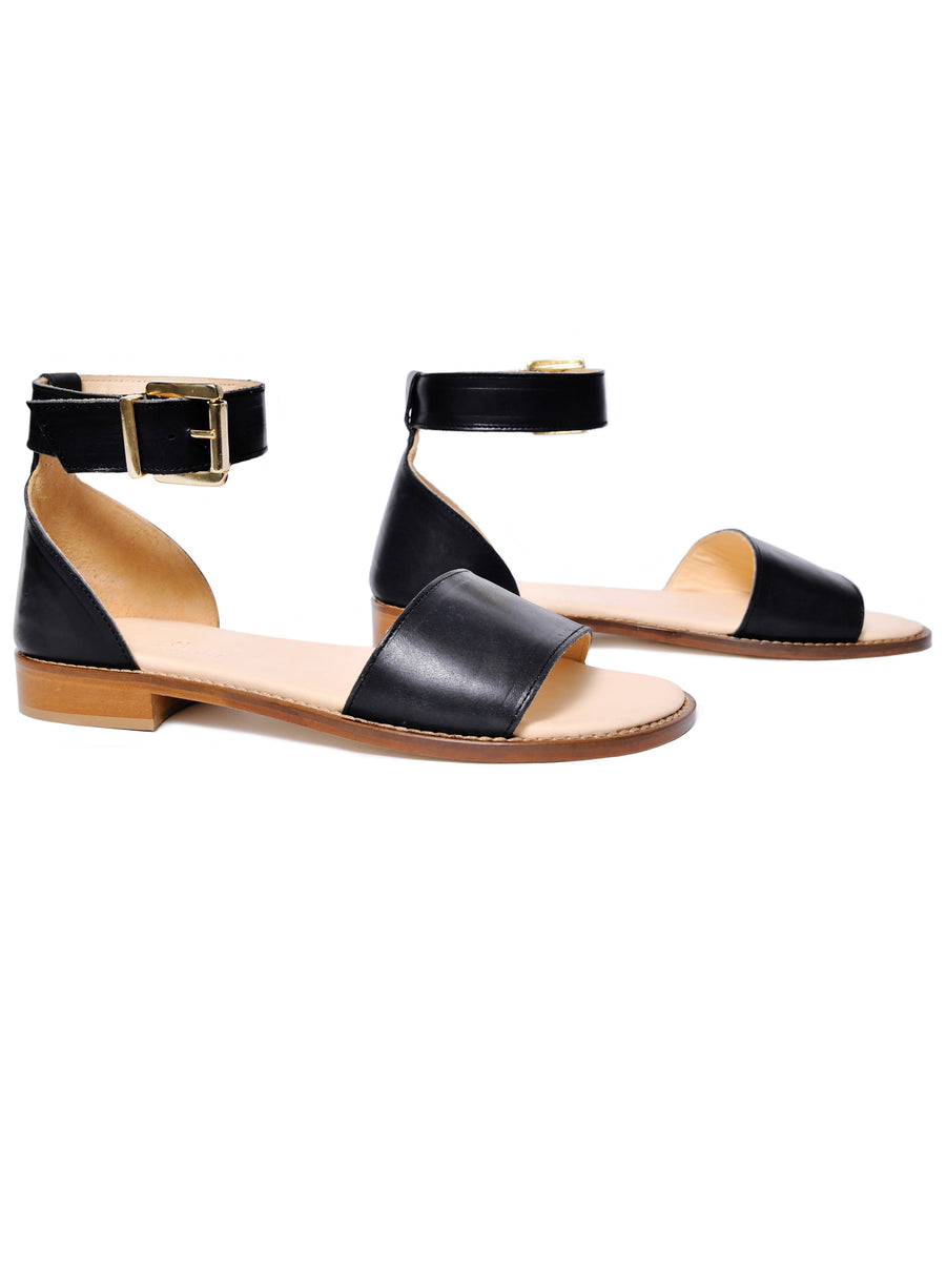 Black coloured sustainable sandal with golden buckles by ALINASCHUERFELD
